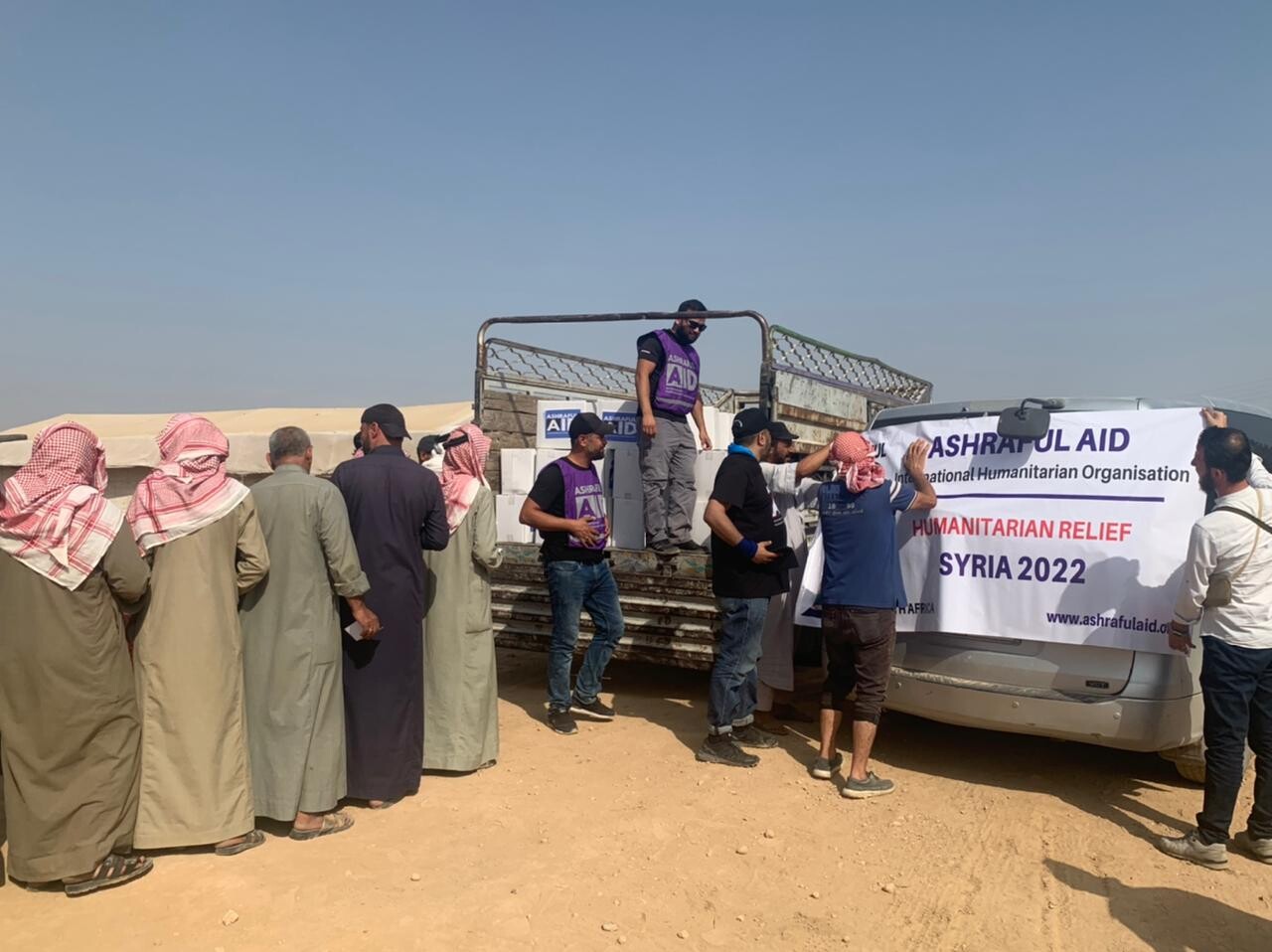 Ashraful Aid volunteers unloading relief parcels from a truck during a humanitarian distribution