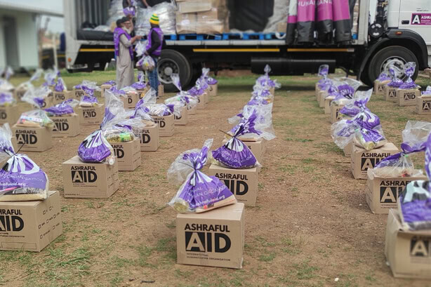 Rows of Ashraful Aid food hampers laid out on the ground ready for distribution