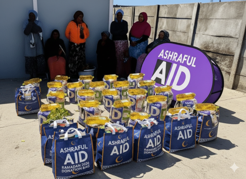 A split-screen graphic for Ashraful Aid. The left side shows a real-life photo of blue "Ramadan 2026 Donation Bags" filled with food and oil bottles, with a group of women and an Ashraful Aid sign in the background. The right side features a clean white background with a purple border, displaying the text: "The True Purpose of Fasting in Islam.