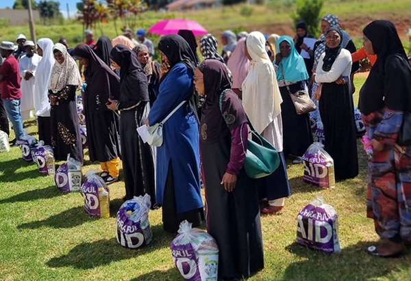 Families receiving Ashraful Aid food parcels during a community distribution
